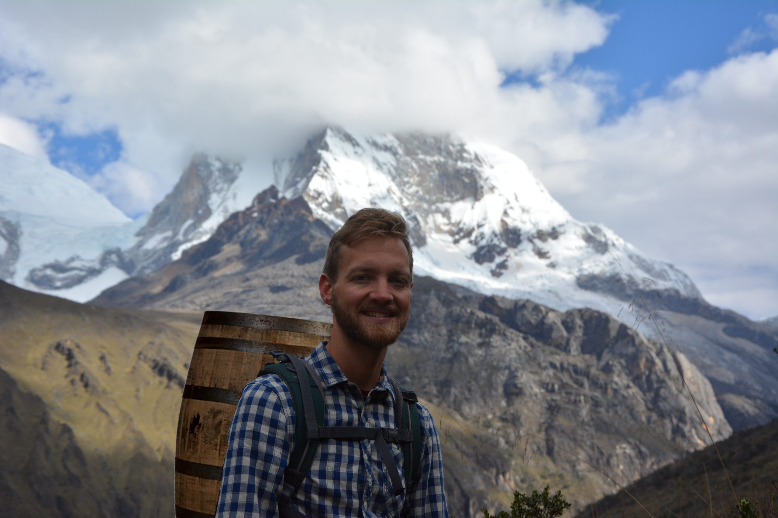 Nick hiking with barrel through the andes