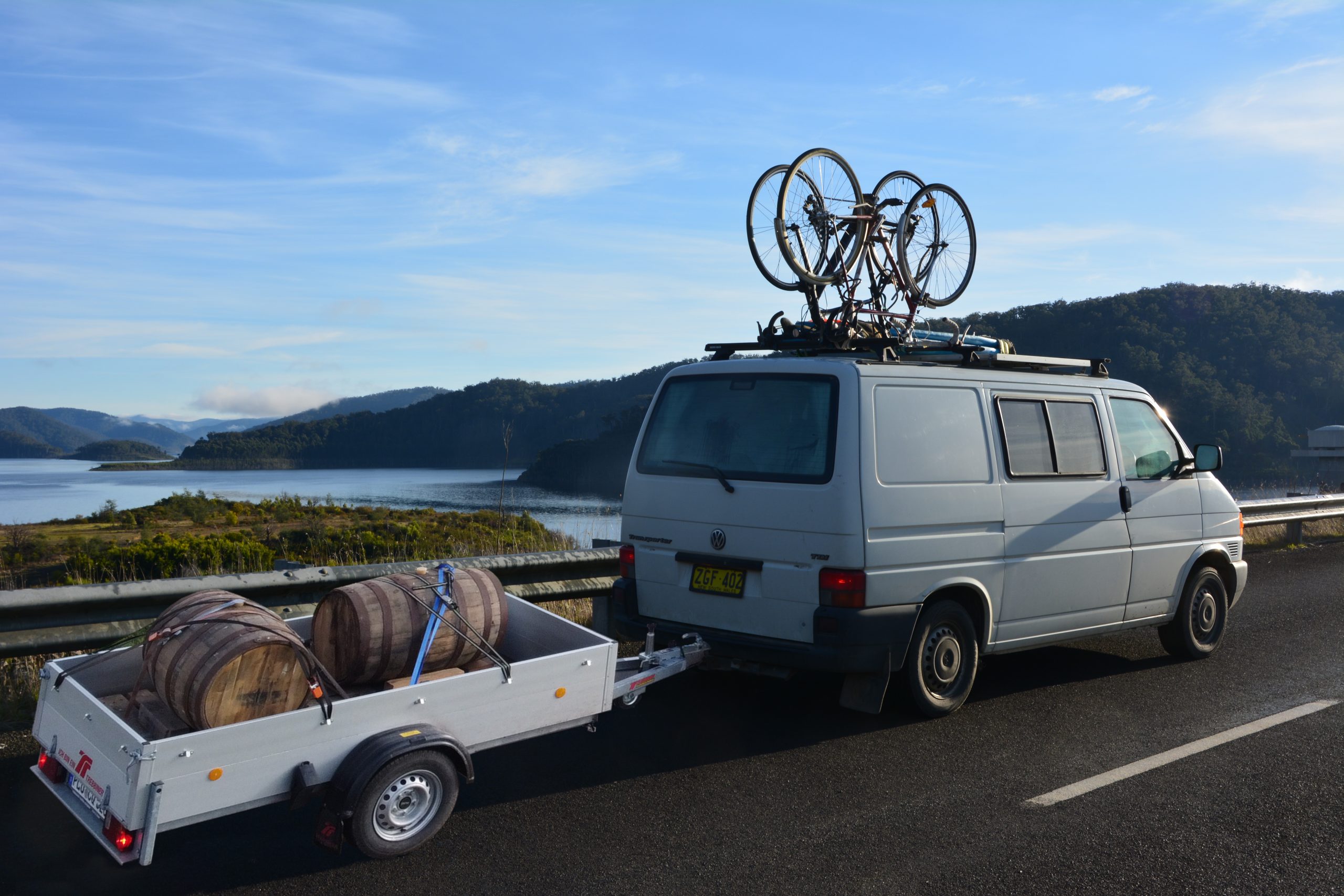 barrels on trailer behind van